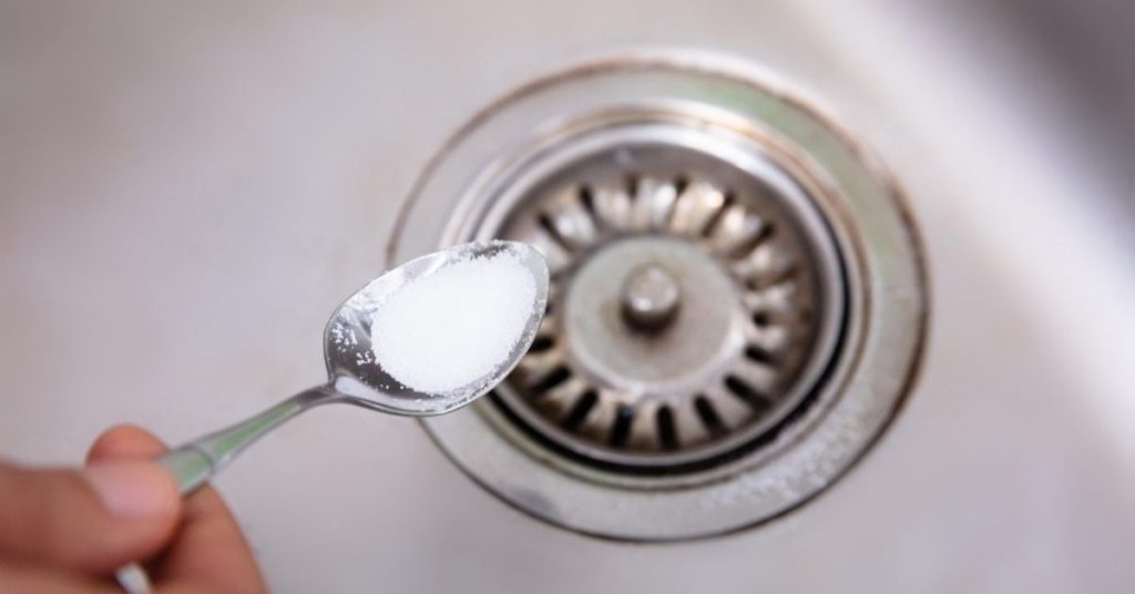 Baking soda on a spoon to put down the drain to get rid of odours - Clean and Tidy Living