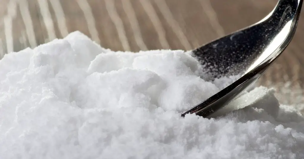 Bicarbonate of soda on surface with a spoon to clean - Clean and Tidy Living