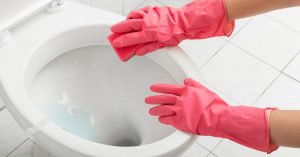 Cleaning a toilet with pink gloves on - How to clean a very stained toilet bowl