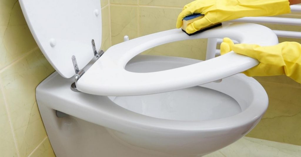 Cleaning a toilet with yellow gloves on - How to clean a very stained toilet bowl