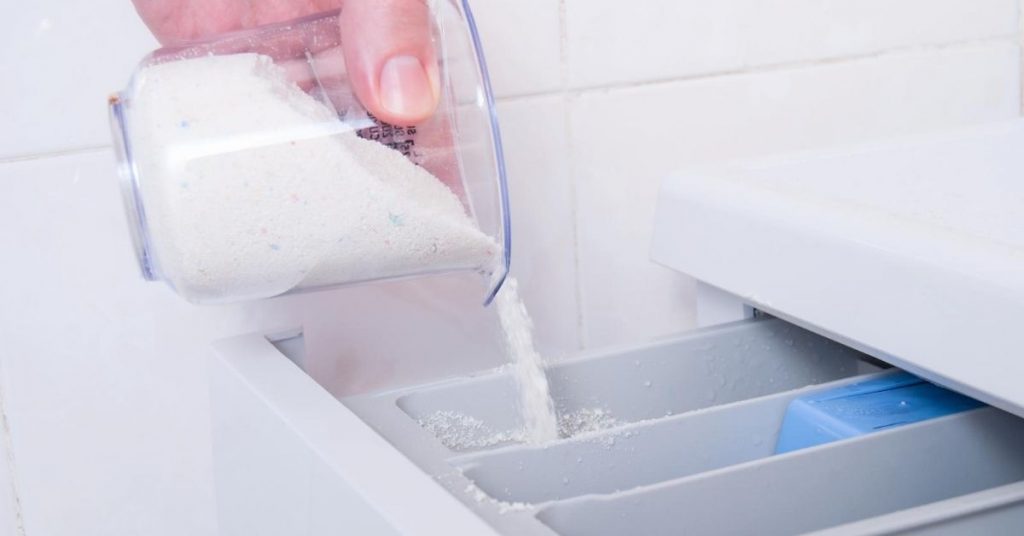 Pouring natural washing powder into a washing machine drawer - Clean and Tidy Living