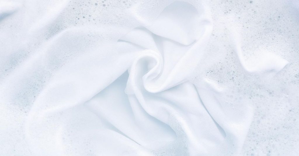 Washing white towels and laundry in soapy water and detergent - Clean and Tidy Living