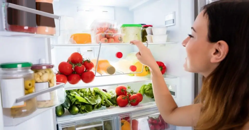 Woman looking at the best fridge freezer under £500 in the UK - Clean and Tidy living