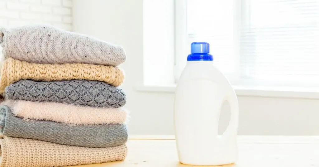 Laundry Detergent Next to a Pile of Clothes - What Temperature Kills Bacteria in a Washing Machine - Clean and Tidy Living